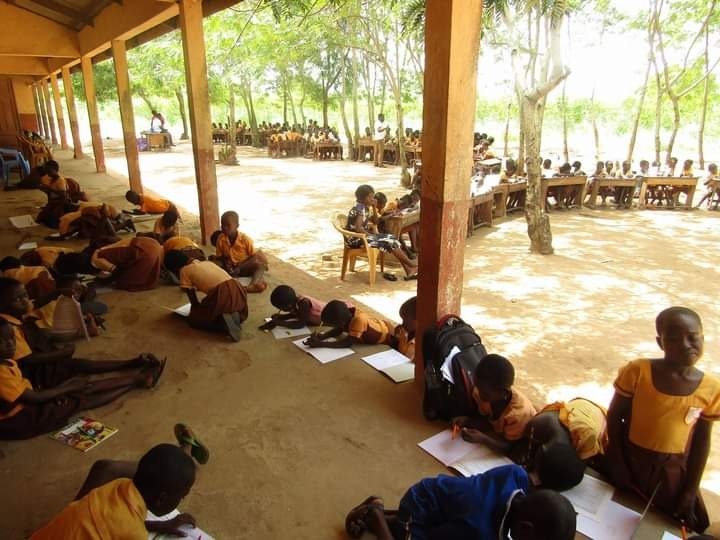 Ghanaian children doing school work outside.