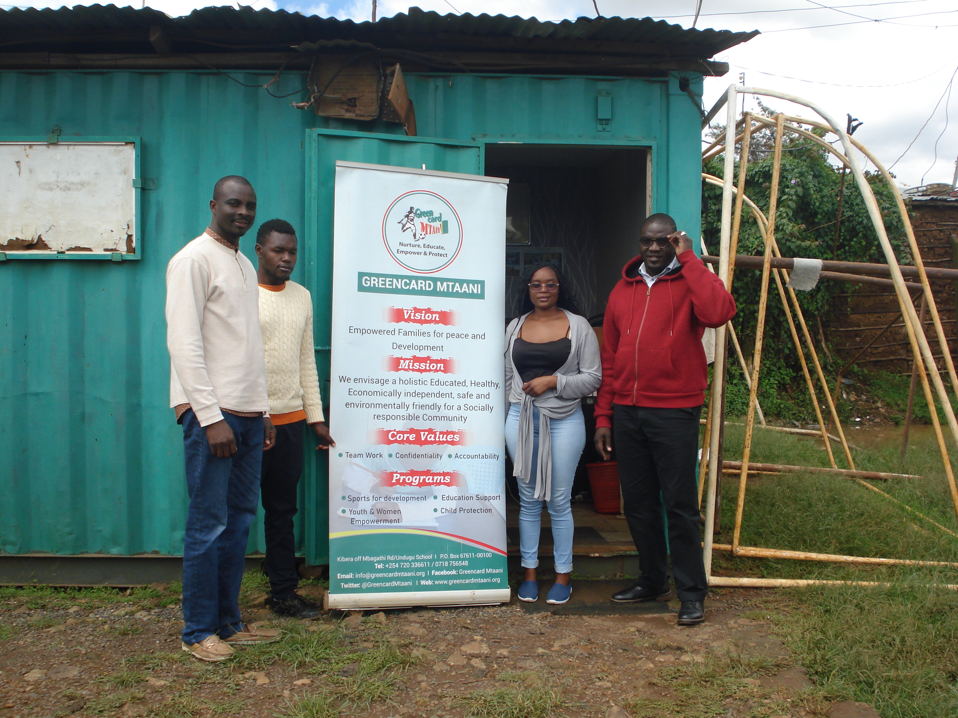 Group of people standing outside the head office of Greencard Mtaani, and NGO based in Kibra, Nairobi, Kenya.